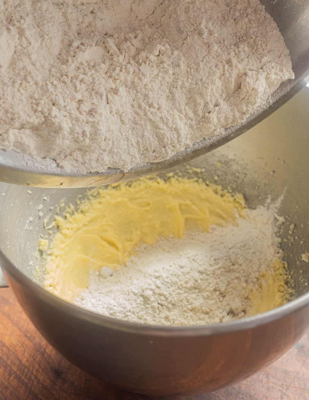 Mixing flour into beaten eggs and butter to make bar cookie crust.