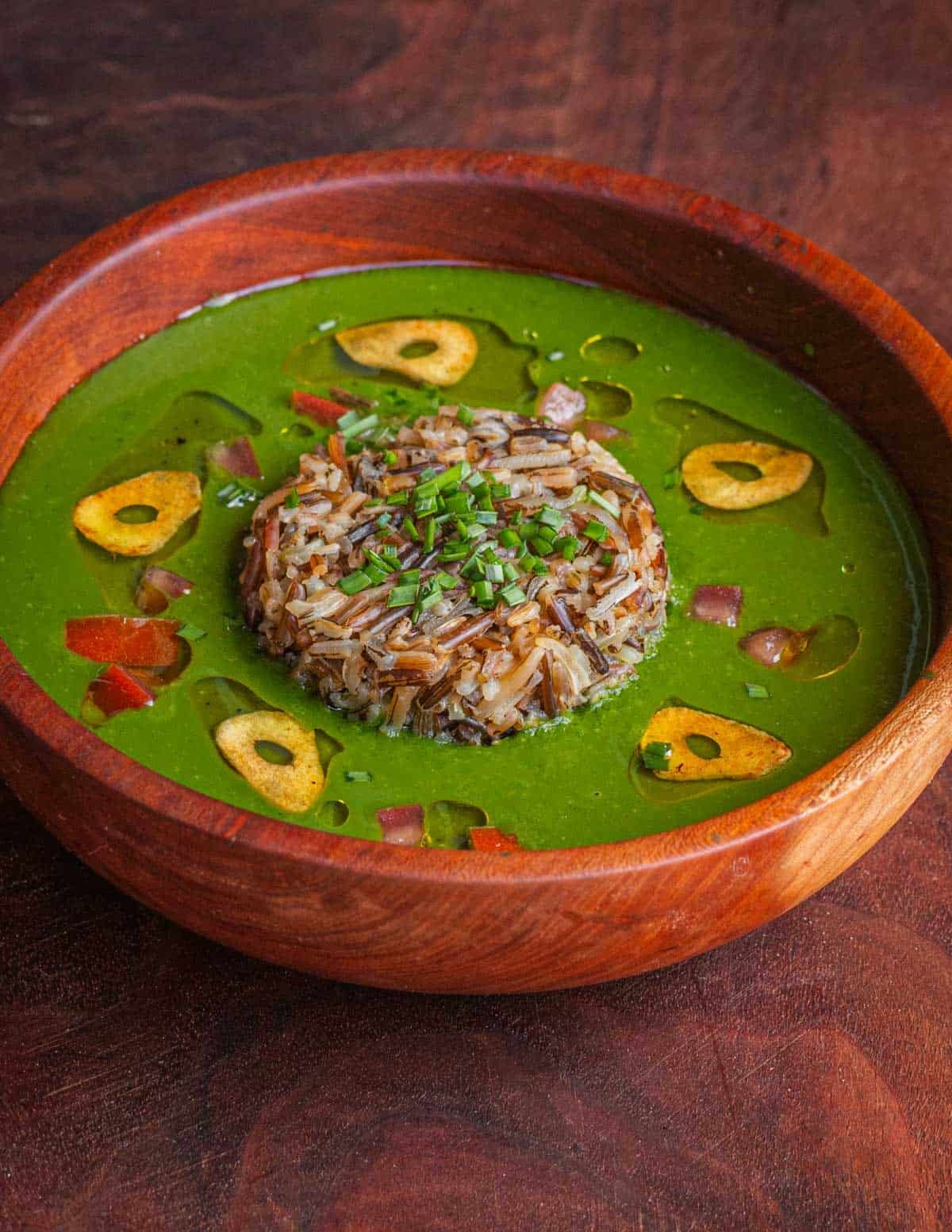 A bowl of molokhia soup made with wild rice and mallow greens garnished with garlic oil.