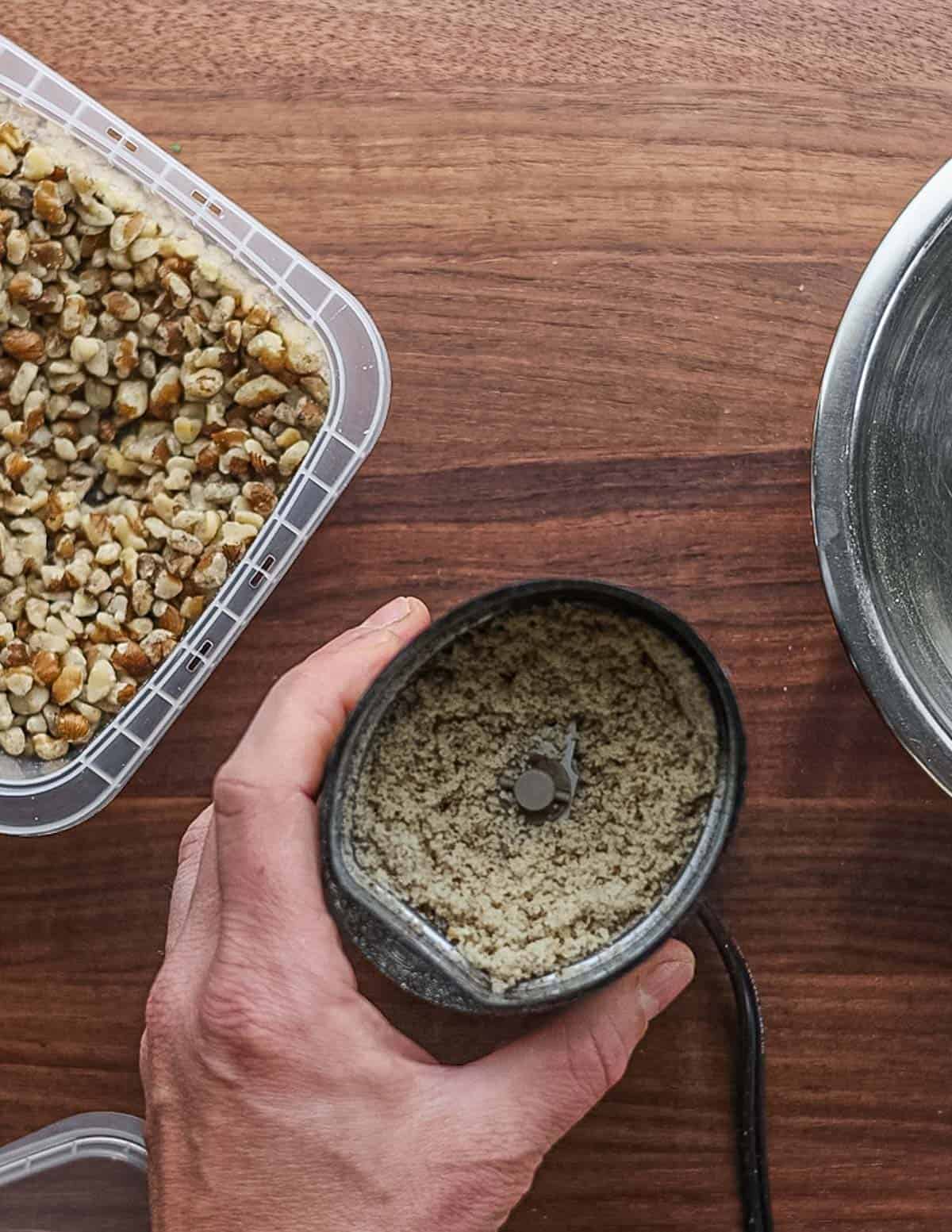 Grinding black walnuts into flour in a spice grinder.