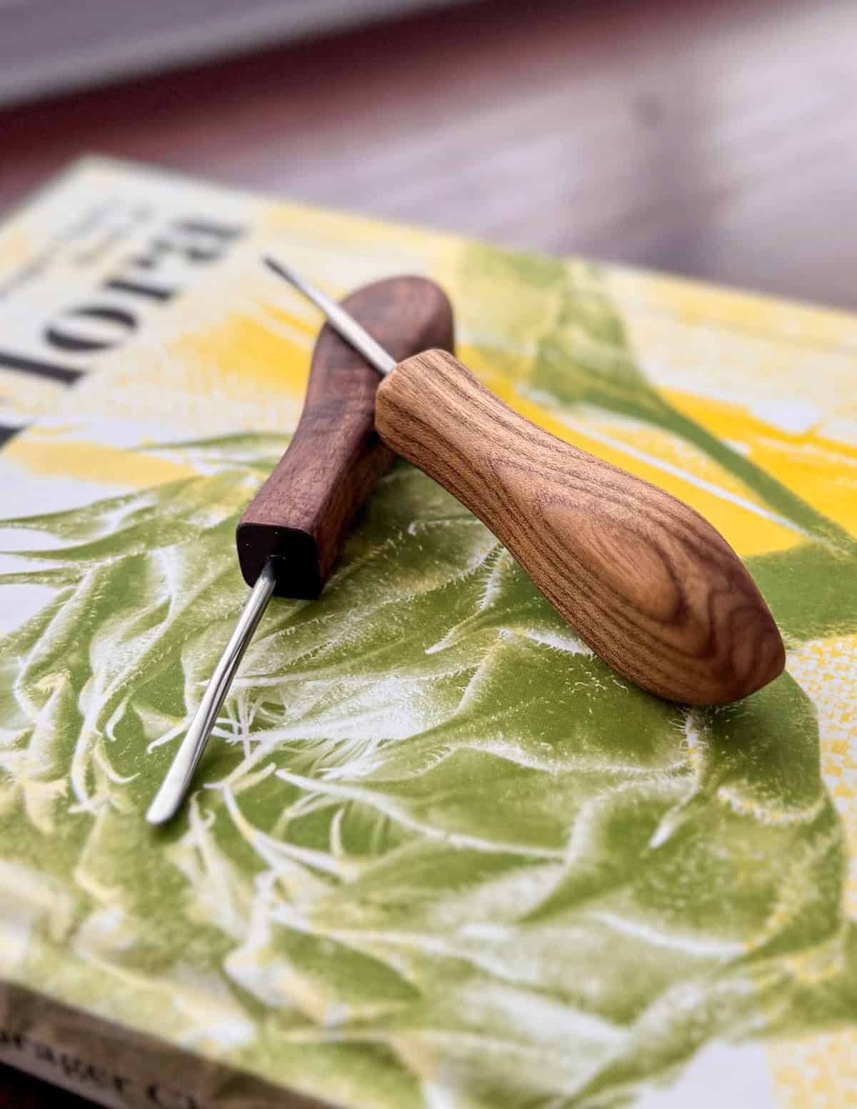Two homemade nut picks on a copy of the Forager Chef's Book of Flora.