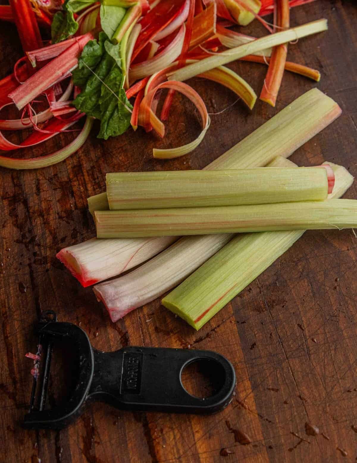 Peeling rhubarb with a vegetable peeler.
