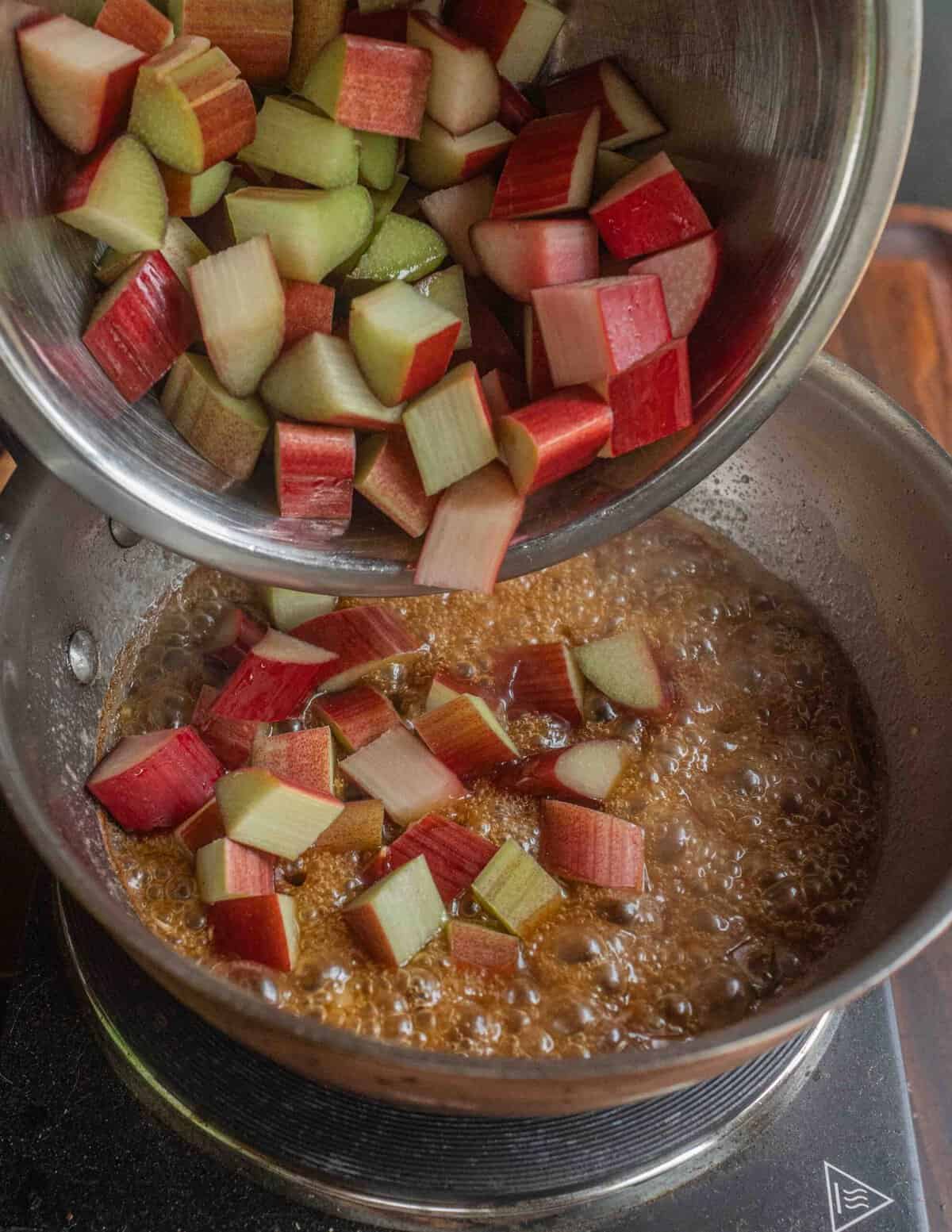 Adding diced rhubarb to a pot of sauce.