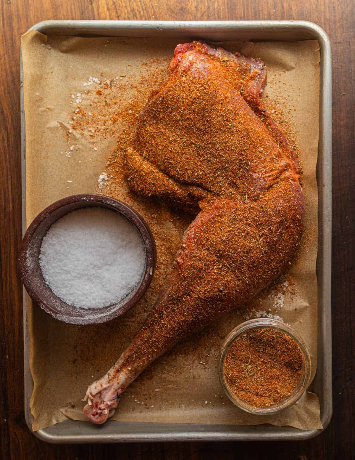 Seasoning a wild turkey leg with a dry rub.