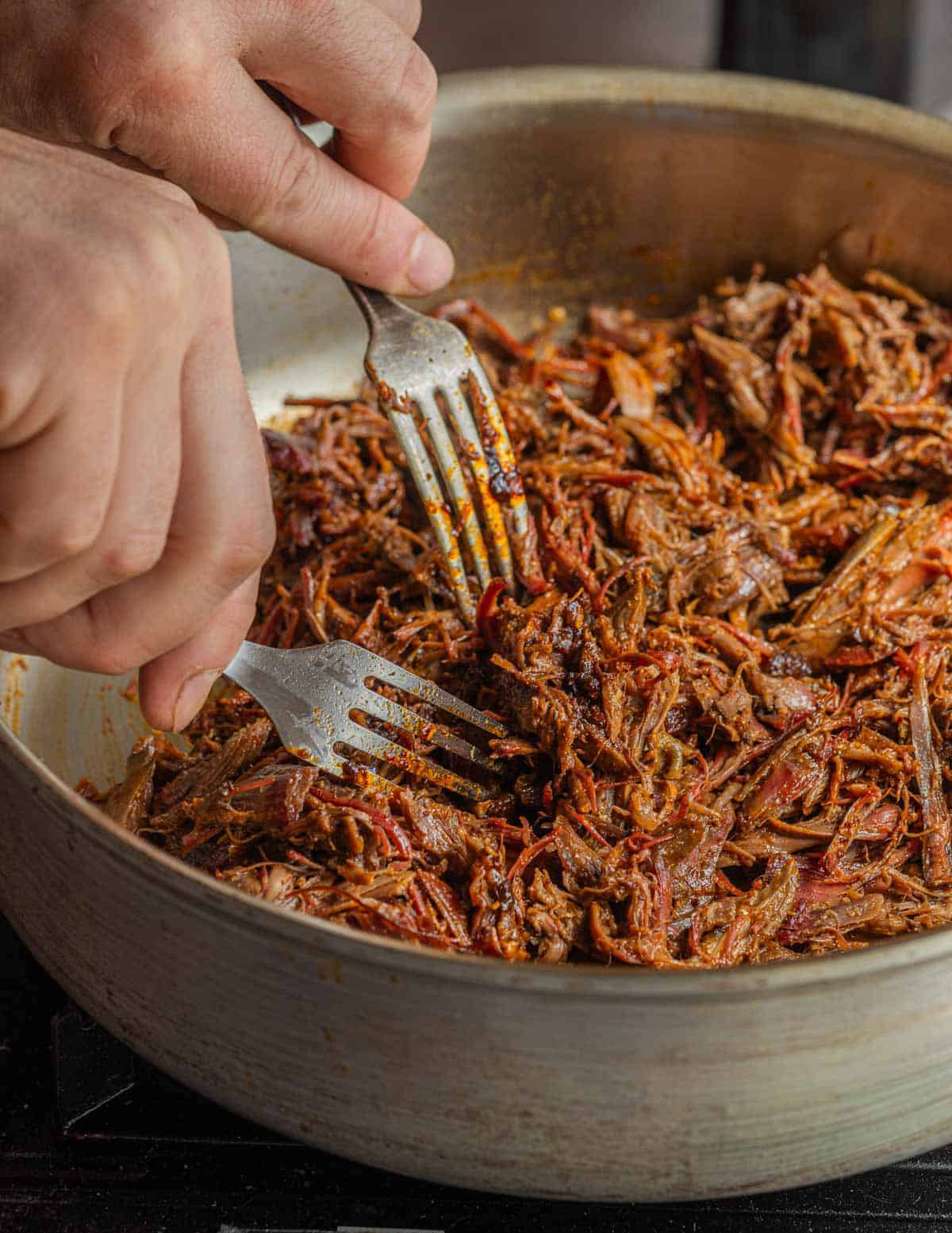 Shredding wild turkey meat with two forks.