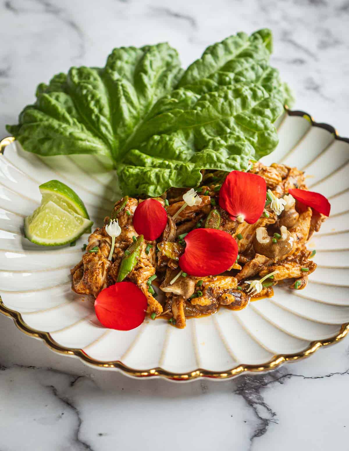 Chicken salad with harissa, garlic scapes, begonias and lettuce leaf basil.