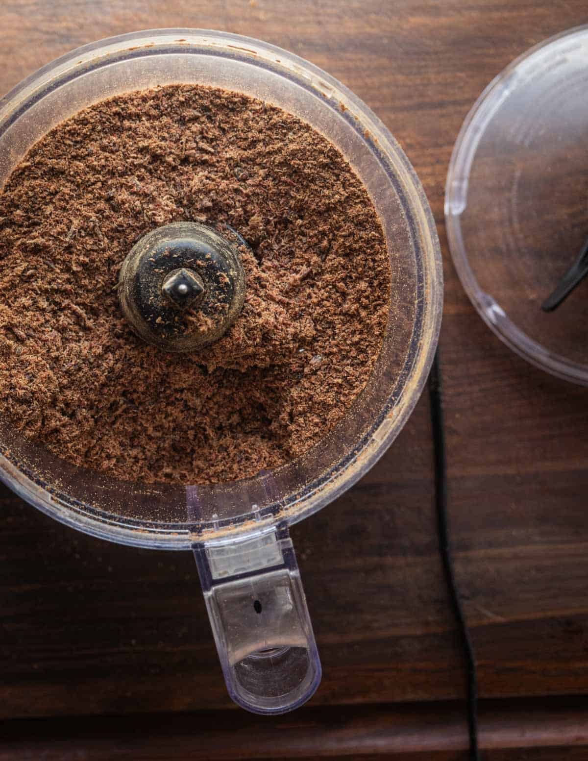 Grinding the dried smoked venison meat in a food processor.