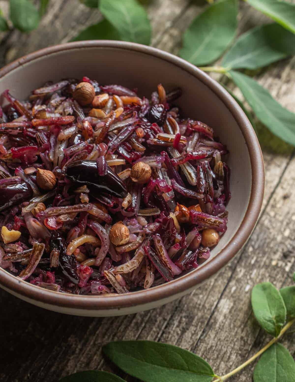 A bowl of wild rice cooked with honeyberries, wild hazelnuts, butter and maple syrup for breakfast.