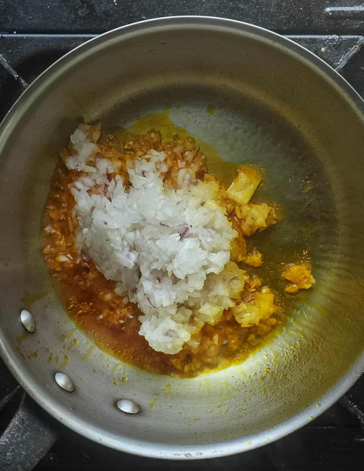 Cooking ground aromatic vegetables in African palm oil.