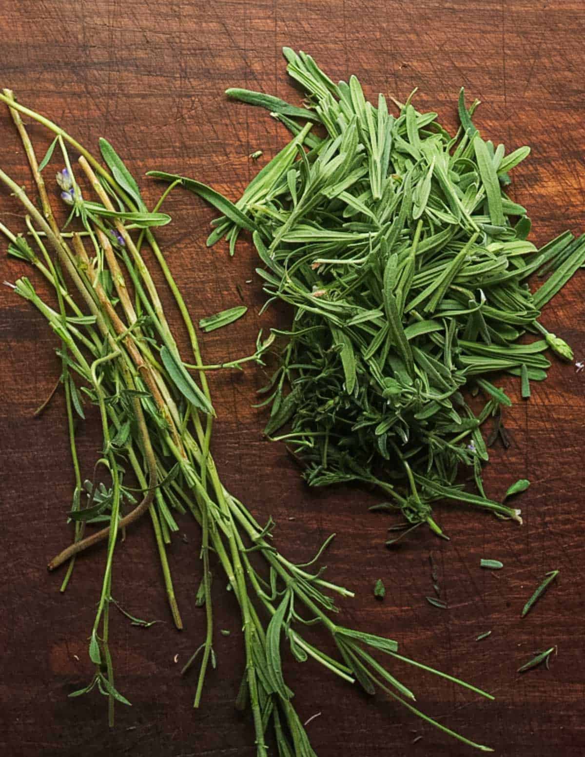 A pile of fresh lavender leaves next to the stems to be discarded.