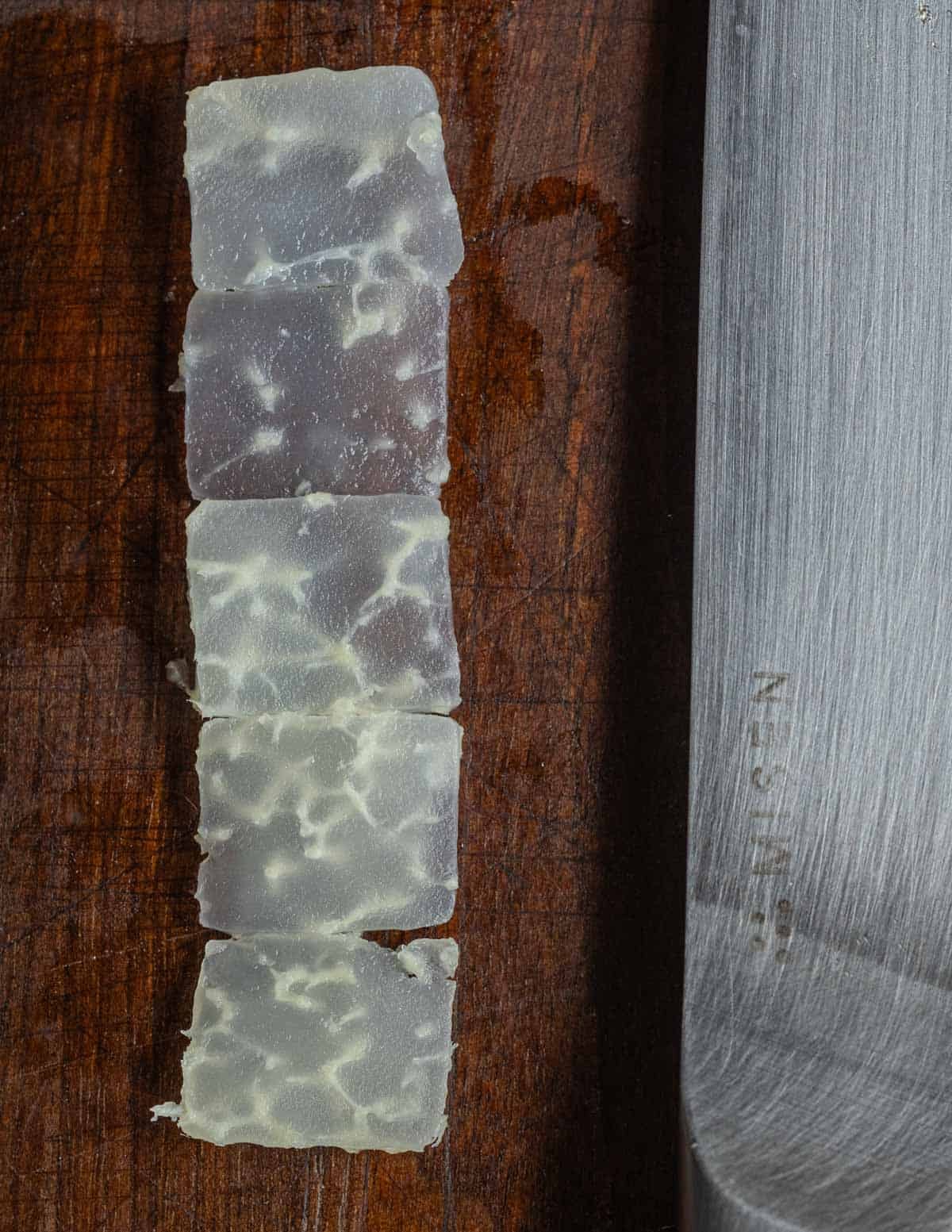 A close up image of translucent cooked slices of kohlrabi showing the tough fibers that can run through older bulbs and isn't pleasant to eat.