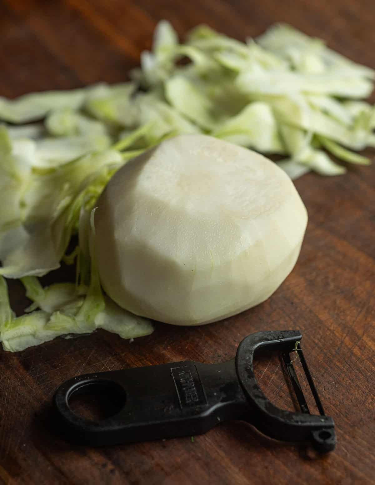 A finished peeled kohlrabi bulb showing perfect white flesh.