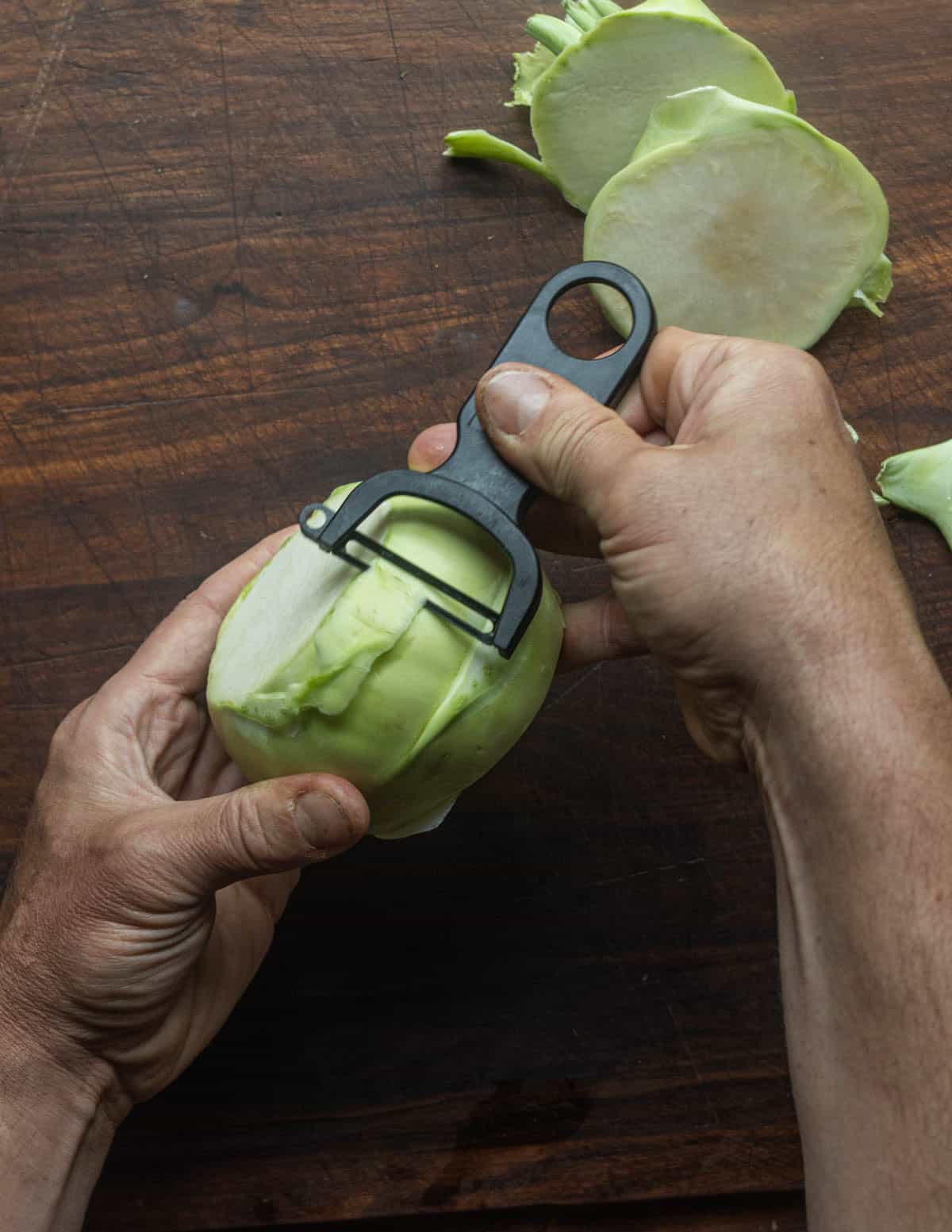 Peeling a kohlrabi bulb with a Kuhn rikon y-shaped peeler.