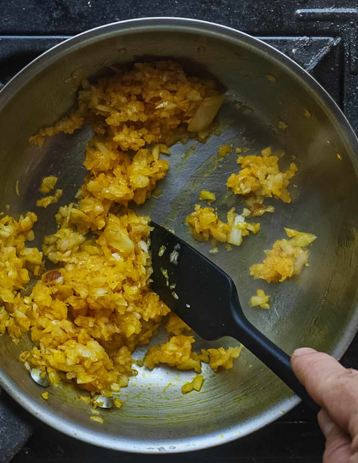 A mixture of onion, garlic, ginger, shallot, leek and eggplant cooking in palm oil.