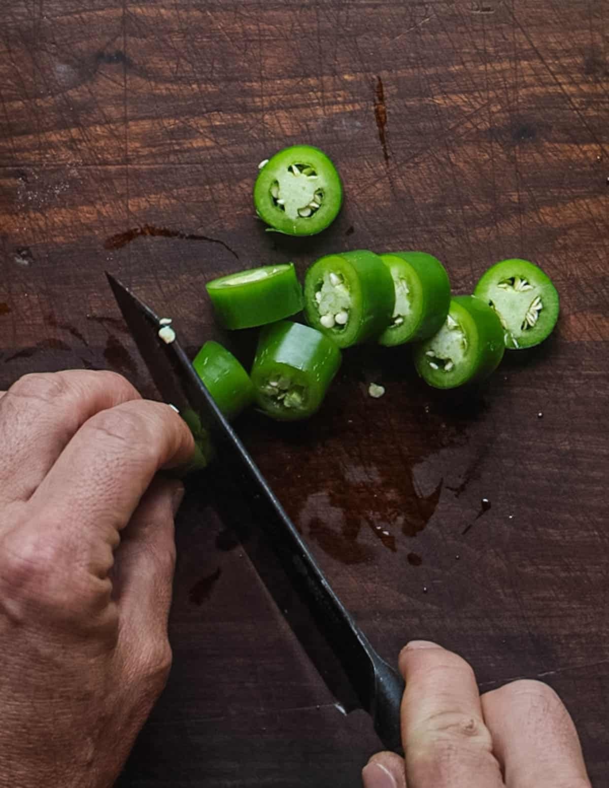 Cutting up a serrano pepper to add to salsa.