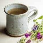 A mug of warm wild clover tea made with red clover, purple prairie clover, and sweet clover.