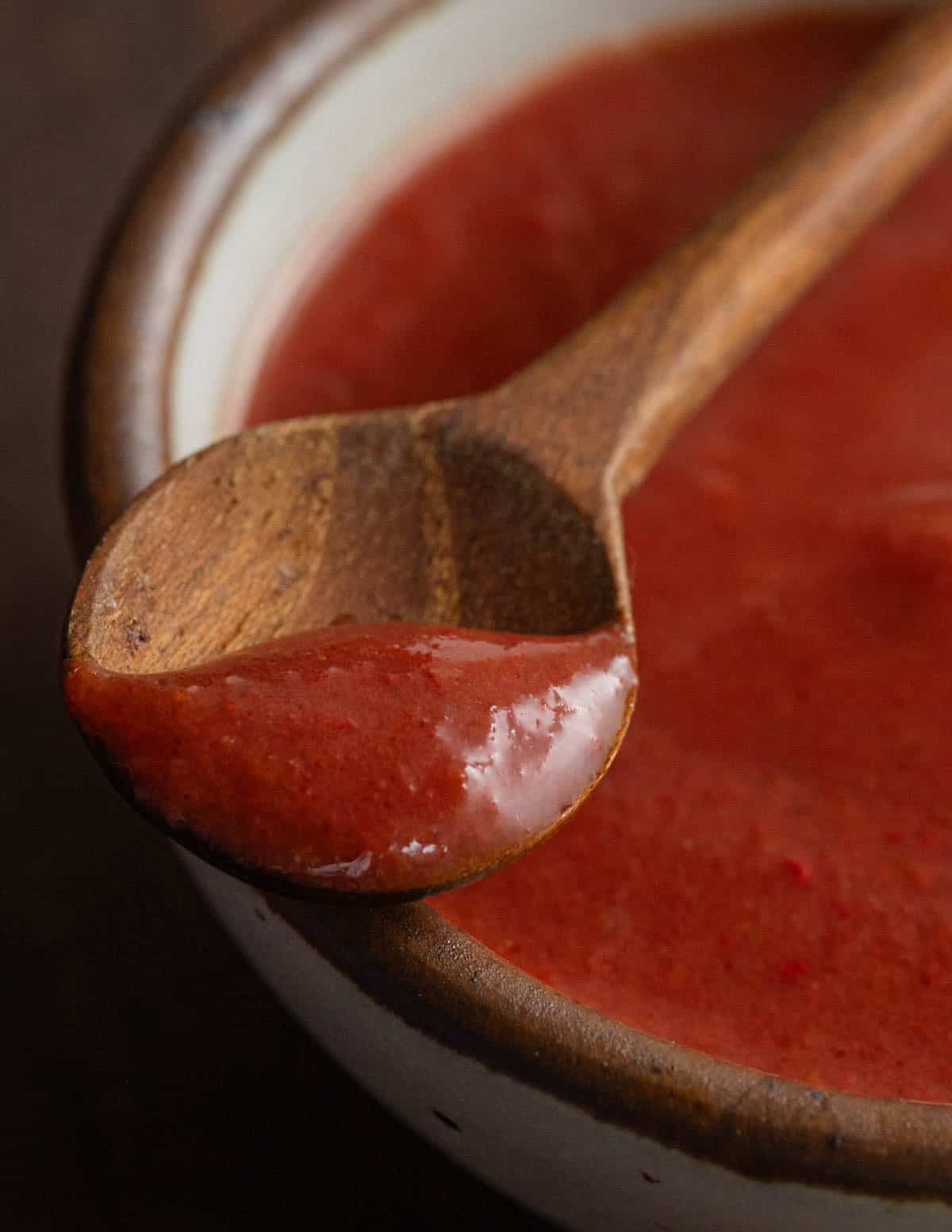 A small wooden spoon filled with maple-autumn olive sauce.