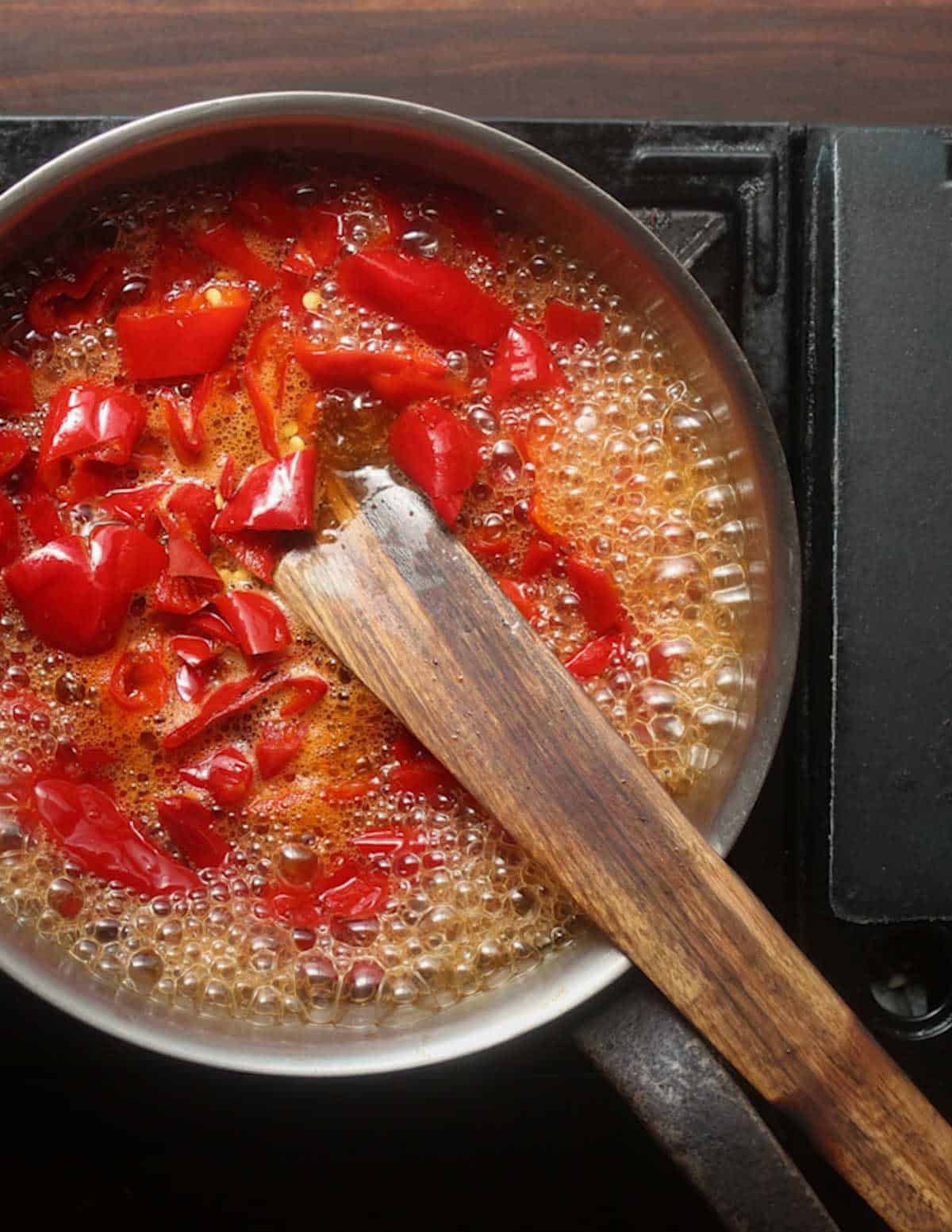 A pan of fermented peppers, maple syrup and vinegar boiling.