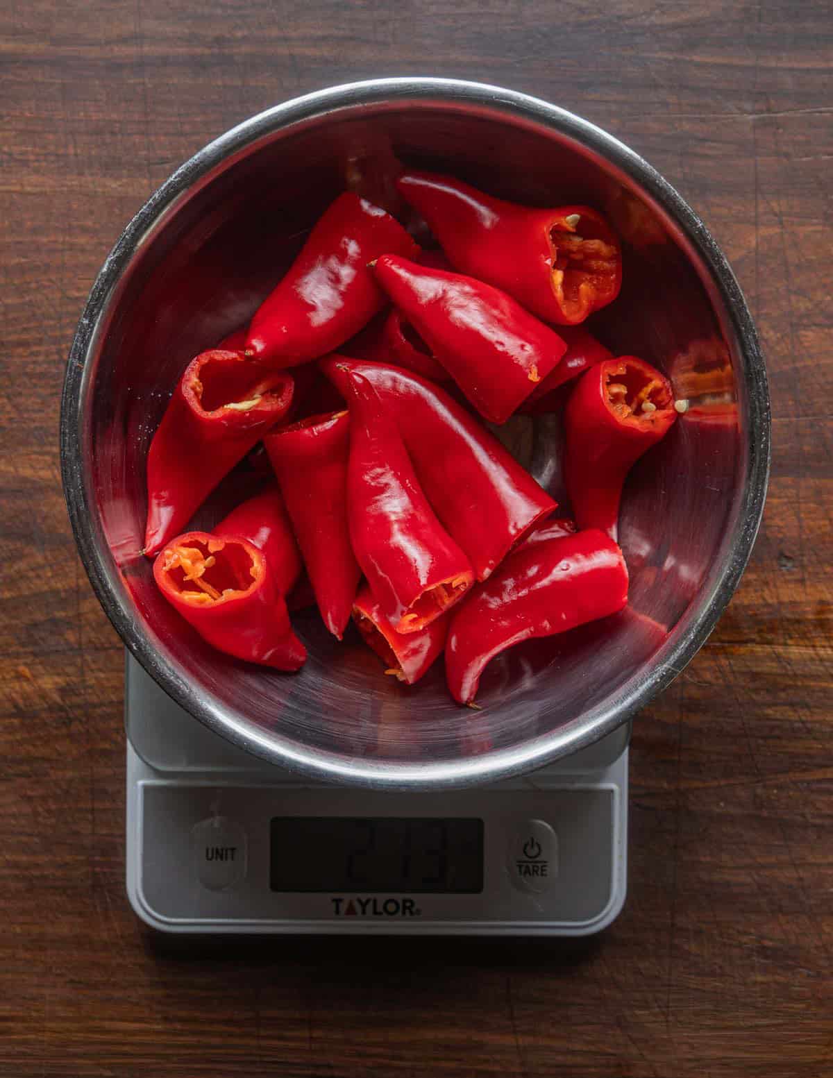 De-stemmed and seeded red Fresno peppers being weighed in a bowl before adding salt prior to fermenting.