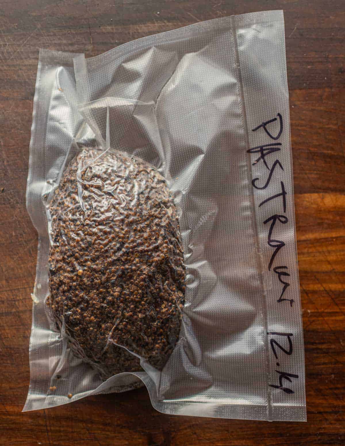 A breast of goose pastrami crusted with peppercorns and coriander vacuum sealed.