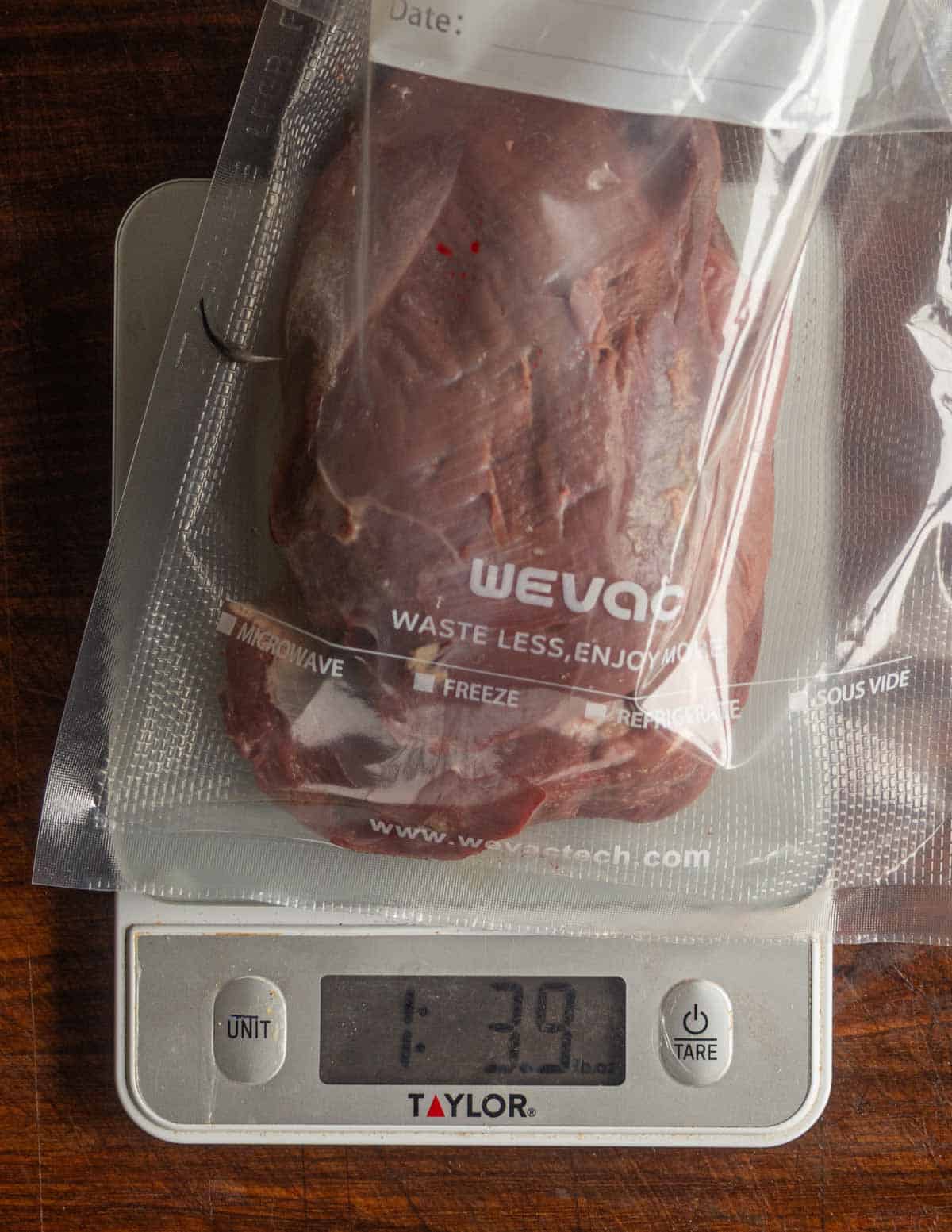 Canada goose breasts in a vacuum bag on a scale being weighed.