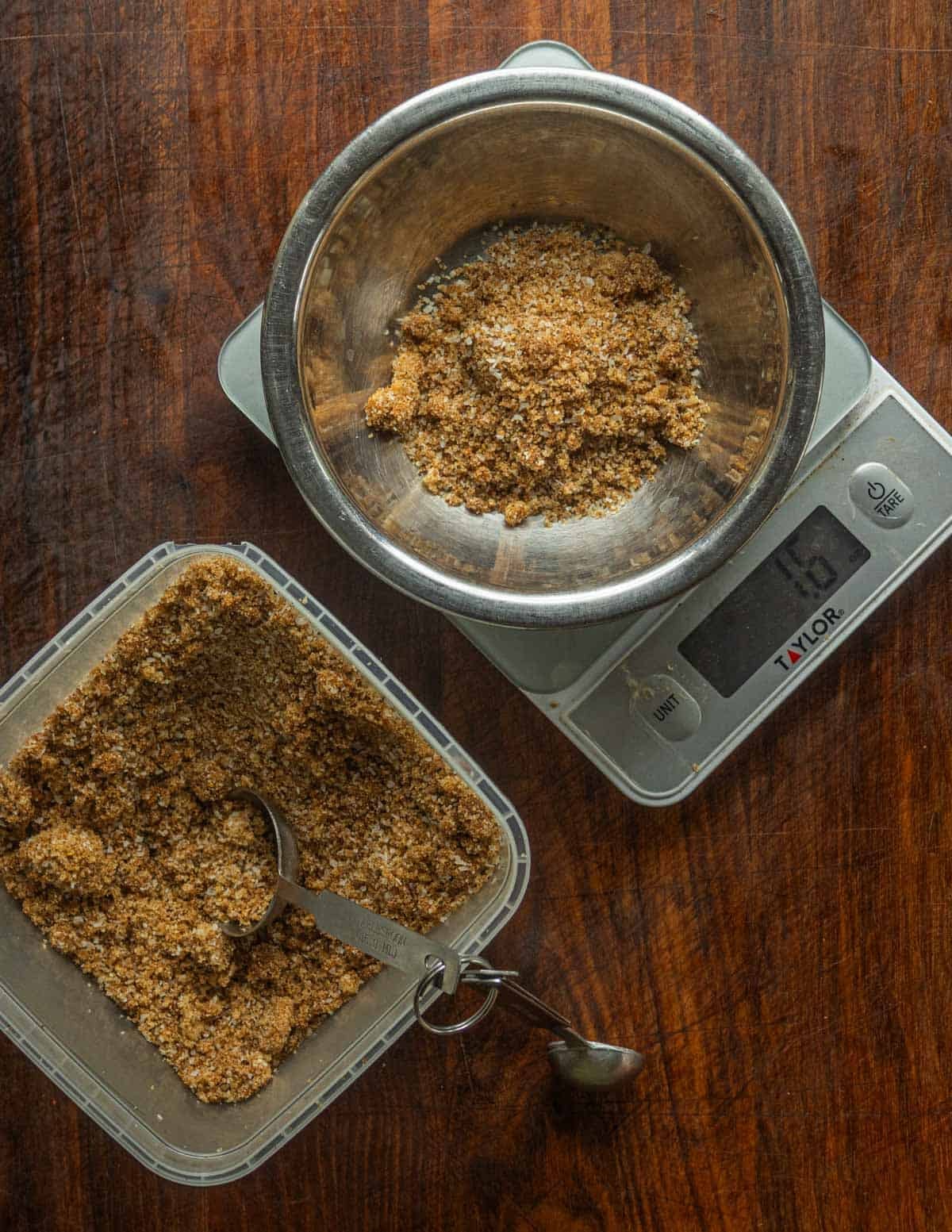 A deli container filled with cure being weighed out before being added to meat.