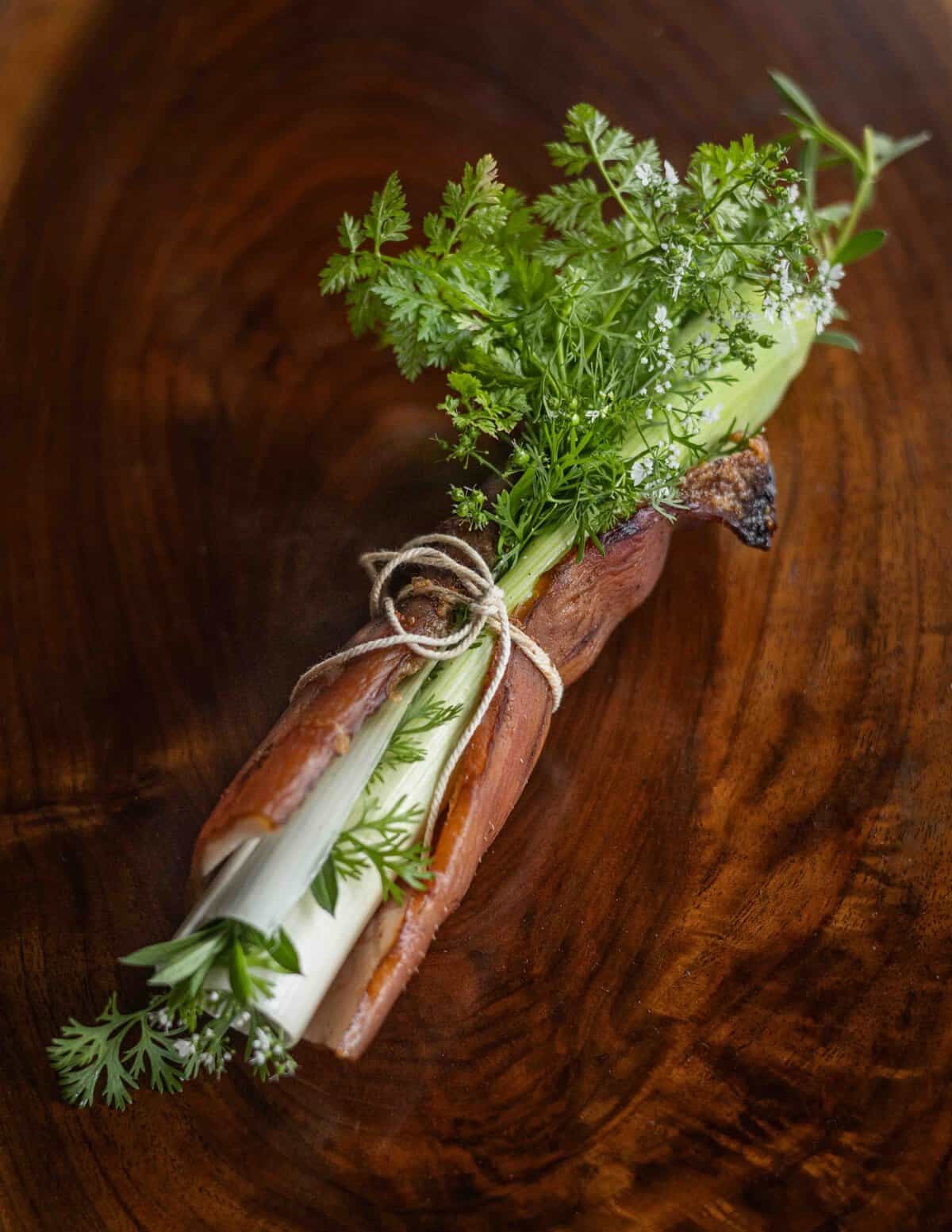 A piece of smoked pork skin wrapped around fresh herbs for flavoring stock and broth.